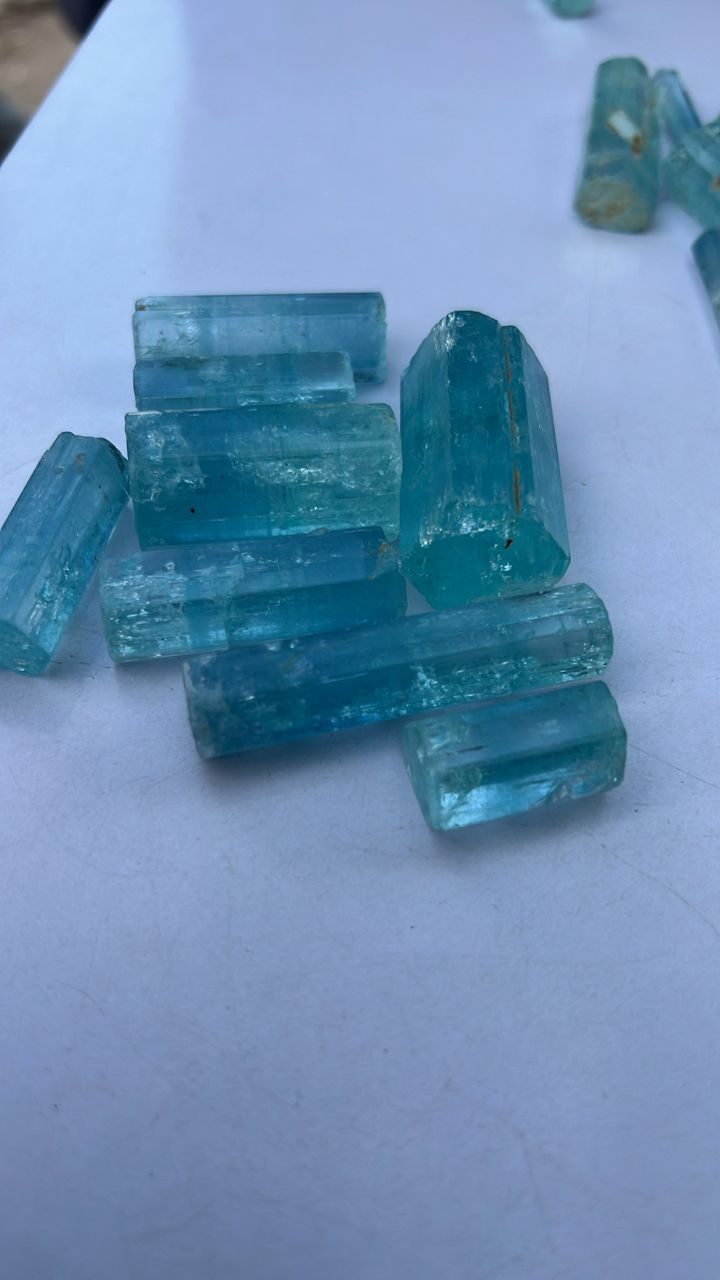 Clear blue aquamarine prisms in hand